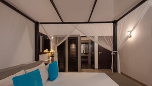 A modern hotel room with a large bed, a nightstand, and a view of the hallway.
