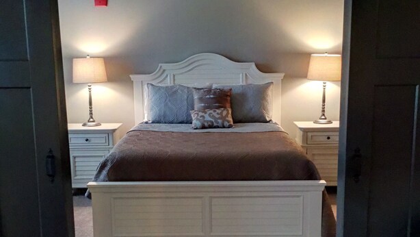 A bedroom with a white bed, two nightstands, and two lamps. - **Bluegrass Getaway** (Lexington)