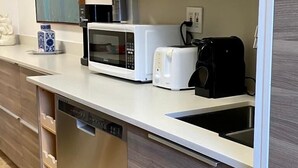 A modern kitchen with a built-in dishwasher, a microwave, a toaster, and a coffee maker. - SEASONAL RENTAL IN KEY BISCAYNE (Key Biscayne)