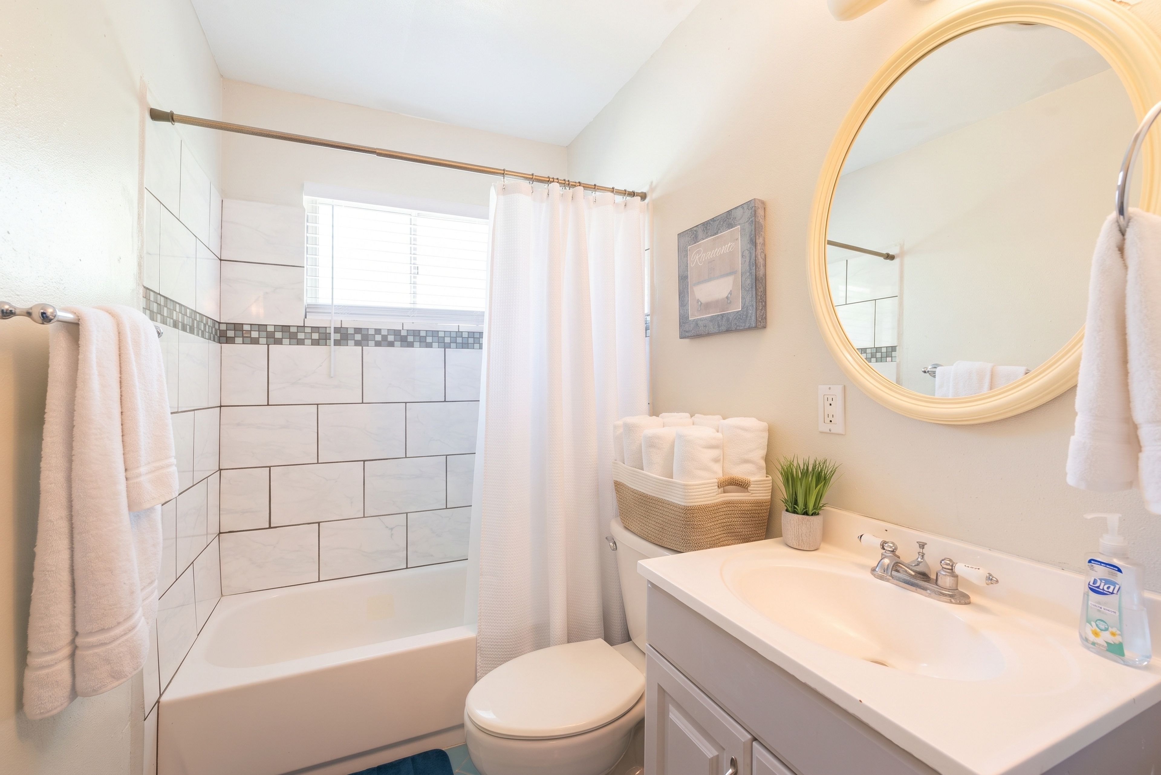 Un baño con bañera, inodoro, lavabo y espejo.