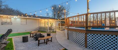 A patio area with outdoor seating, a pool, and string lights.