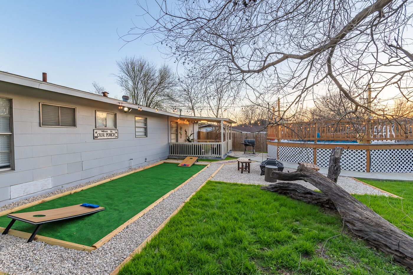 Une maison avec un patio, une pelouse et une terrasse en bois.
