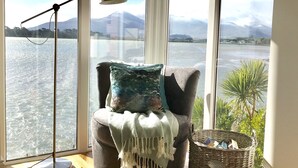A cozy seating area with a view of a lake and mountains.