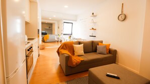 A modern living room with a sofa, a coffee table, and a kitchen area in the background. - Historic center of Ponta Delgada - Balcony and Free Wifi (Ponta Delgada)
