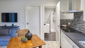 Eine moderne Küche mit schwarzem Arbeitsplatz, einem eingebauten Herd und einer Edelstahl-Dunstabzugshaube.