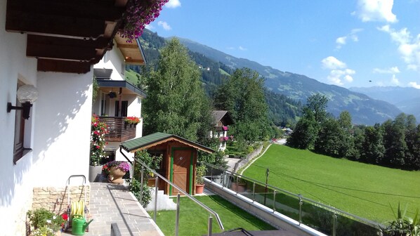 A balcony with a view of a green valley and mountains.
