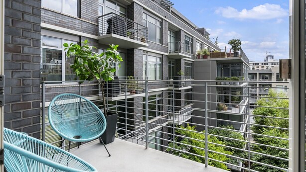 A modern apartment with a balcony, metal railings, and potted plants. - Pearl Pad: Enjoy River, Shopping, Dining.  Balcony, Garage  and free EV chging! (Portland)