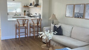 Una sala moderna con sofá, una mesa de centro y un comedor con sillas y una mesa.