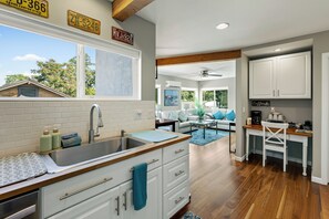 A modern kitchen with a large sink, wooden countertop, and a view of the outdoors.