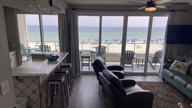 Ein Wohnzimmer mit Blick auf den Strand, einem Essbereich und einer Couch.