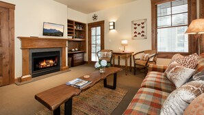 A cozy living room with a fireplace, a sofa, a coffee table, and a bookshelf. - Perfect location makes for easy access to downtown, Snow King and more (Jackson)