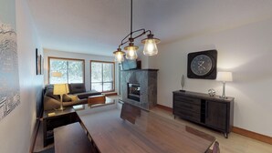 Una sala de estar moderna con chimenea, un sofá, una mesa de centro y un comedor.