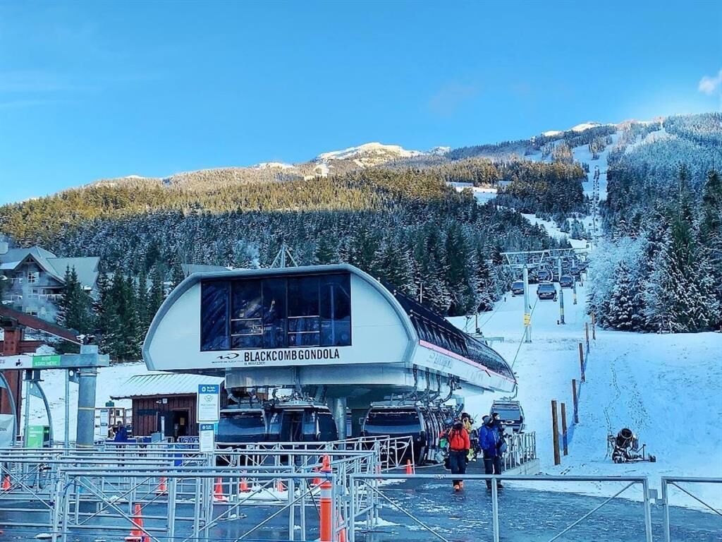 A ski resort with a lift station named 'BLACKCOMB GONDOLA' and a chairlift in the background.