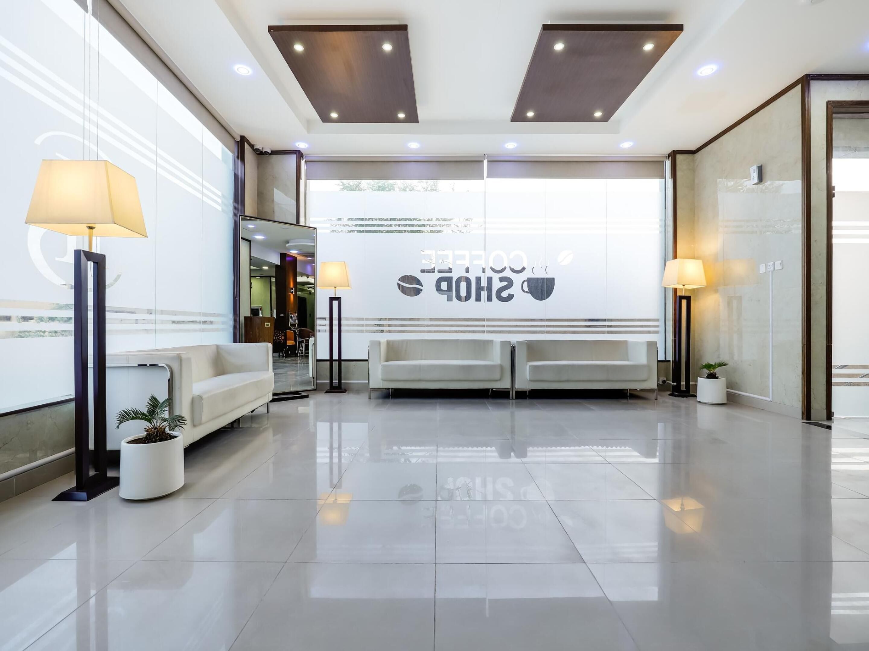 A modern reception area with a coffee shop sign, a reception desk, and seating.