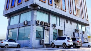 A modern multi-story building with large windows and air conditioning units. - Sh Hotel (Ras Al Khaimah)