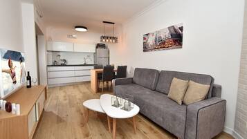 Apartamento premium, 1 cama de casal e sofá-cama, vista para o lago, de frente para a praia | Área de estar | TV de tela plana