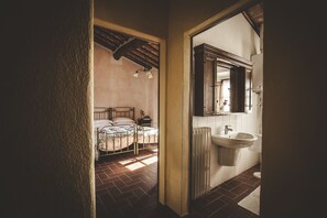 A bedroom with a bed, a nightstand, and a window. - Zampugna (Trequanda)