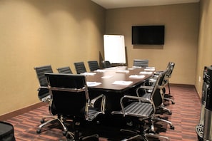 A conference room with a large table, eight chairs, a whiteboard, and a flat-screen TV on the wall. - Four Points by Sheraton Grande Prairie (Grande Prairie)