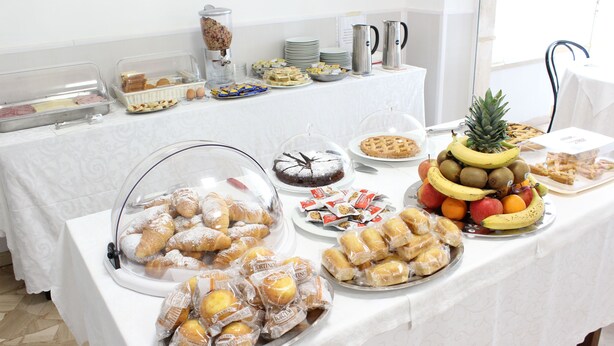 A buffet table with various food items including pastries, fruits, and desserts. - Hotel Luca (Camaiore)