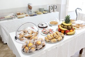 A buffet table with various food items including pastries, fruits, and desserts. - Hotel Luca (Camaiore)