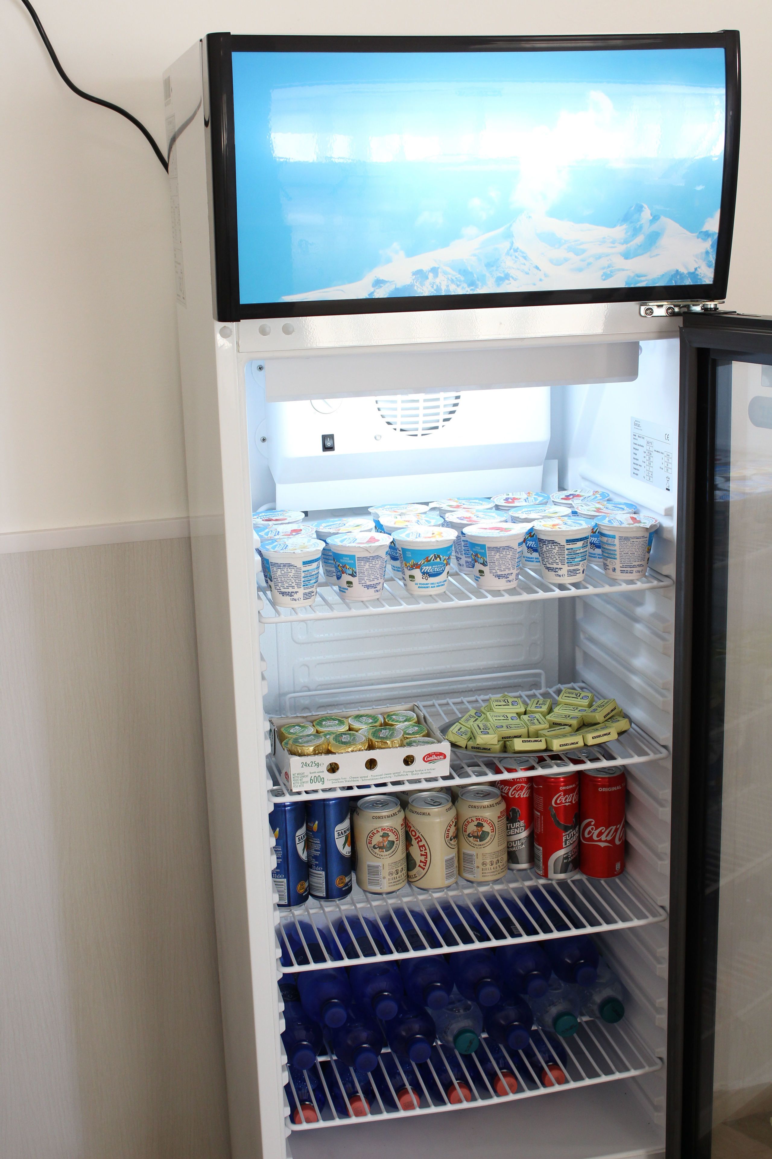 A refrigerator stocked with beverages and dairy products.