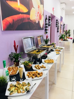 Een buffet met diverse gerechten en een assortiment wijnen.