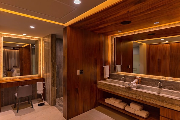 A modern bathroom with wooden paneling, a large mirror, dual sinks, and a chair. - Solaz, A Luxury Collection Resort, Los Cabos a Marriott Hotel (San José del Cabo)