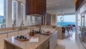 A modern kitchen with a large island, a dining area with a view, and a large window overlooking the ocean. - Solaz, A Luxury Collection Resort, Los Cabos a Marriott Hotel (San José del Cabo)