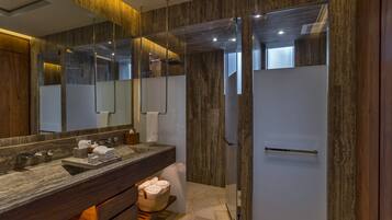 Une salle de bain moderne avec un lavabo en marbre, un grand miroir et une douche à parois de verre.
