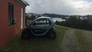 Un coche Renault estacionado en un área con césped y un edificio al fondo.