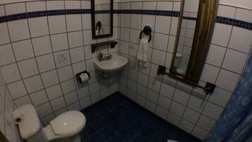 A small bathroom with a toilet, sink, and mirror.