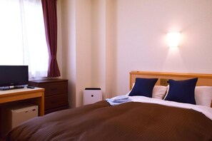 A hotel room with a bed, a desk, a television, and a wall-mounted light fixture. - All In Stay Hakodate (Hakodate)