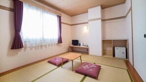 A room with tatami flooring, a futon bed, a television, a desk with a computer, and a wardrobe. - All In Stay Hakodate (Hakodate)