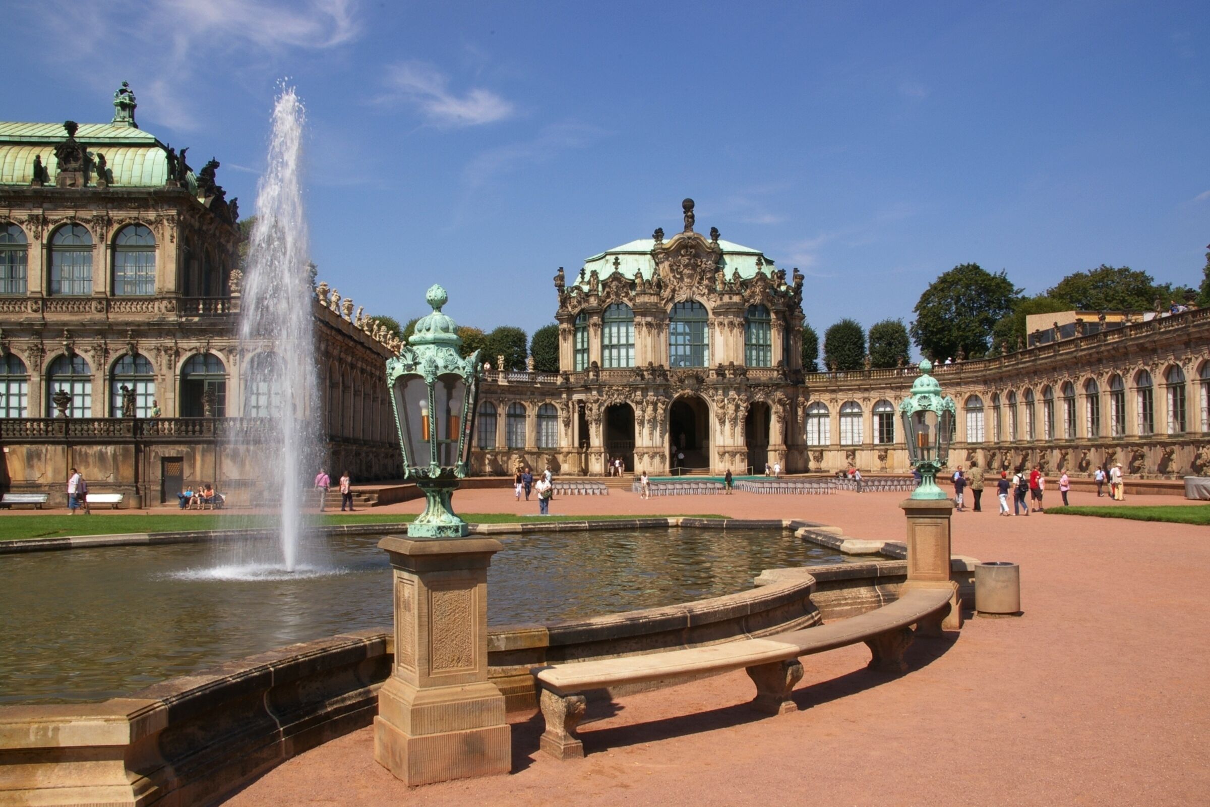 Ein historisches Gebäude mit einer Fontäne, großen Fenstern und aufwendiger Architektur.