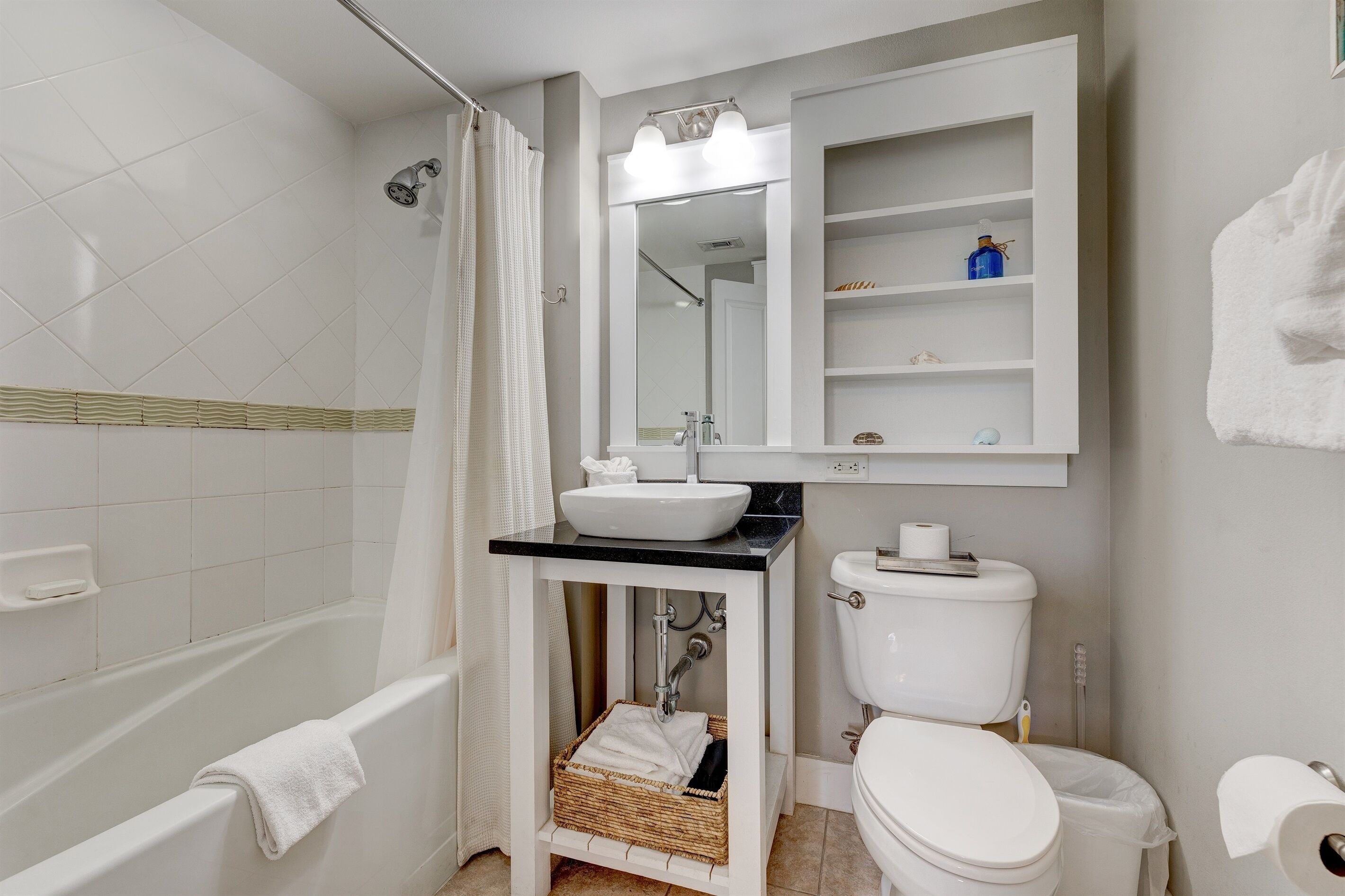 Ein Badezimmer mit Badewanne, Toilette, Waschbecken und einem Spiegelschrank.