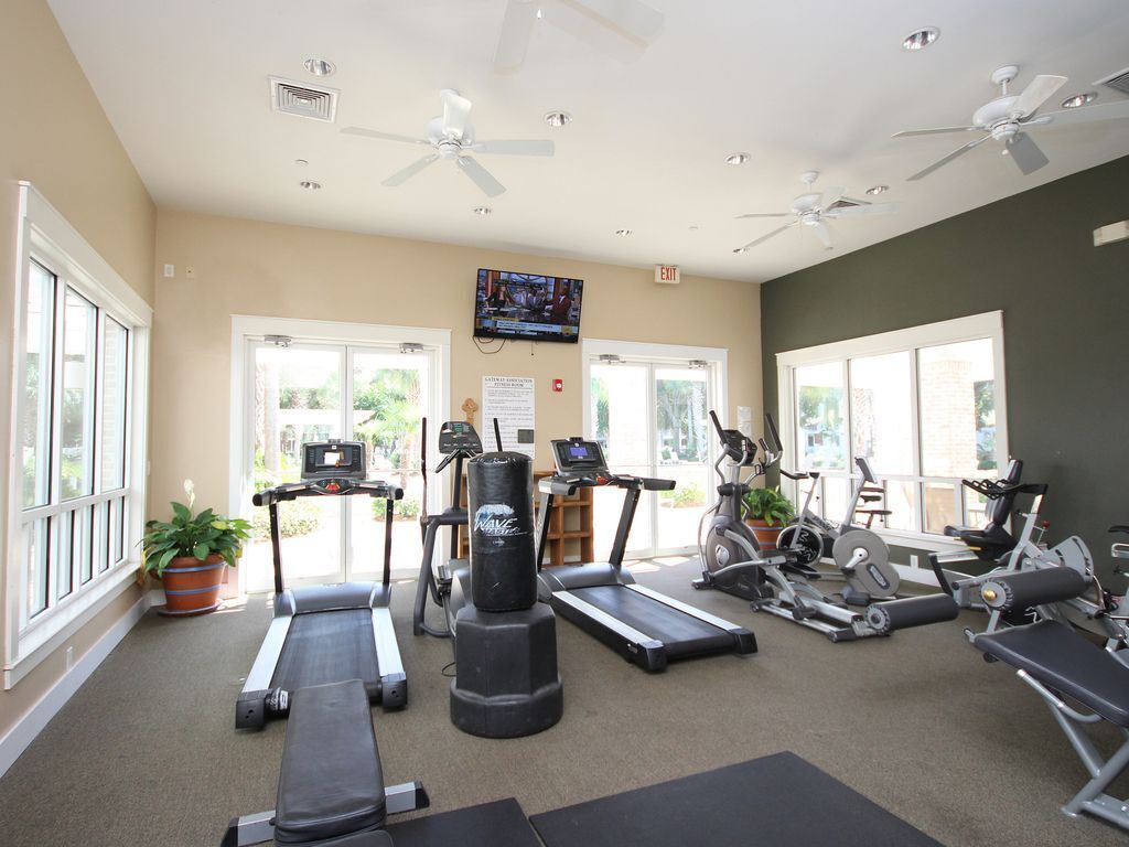 Une salle de sport équipée de tapis de course, de vélos d’appartement et d’un sac de frappe.