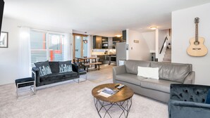 A living room with a sofa, a coffee table, and a dining area with a table and chairs. - Beautiful park like setting- Telluride Lodge Condo  (Telluride)