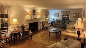 A cozy living room with a fireplace, a sofa, armchairs, and a coffee table.