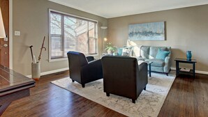 A living room with a sofa, two armchairs, a coffee table, and a side table.