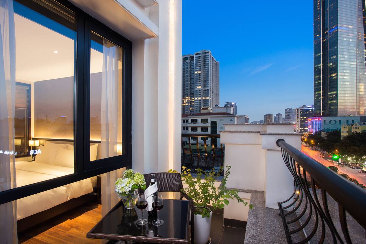A balcony with a table, chairs, and a potted plant.