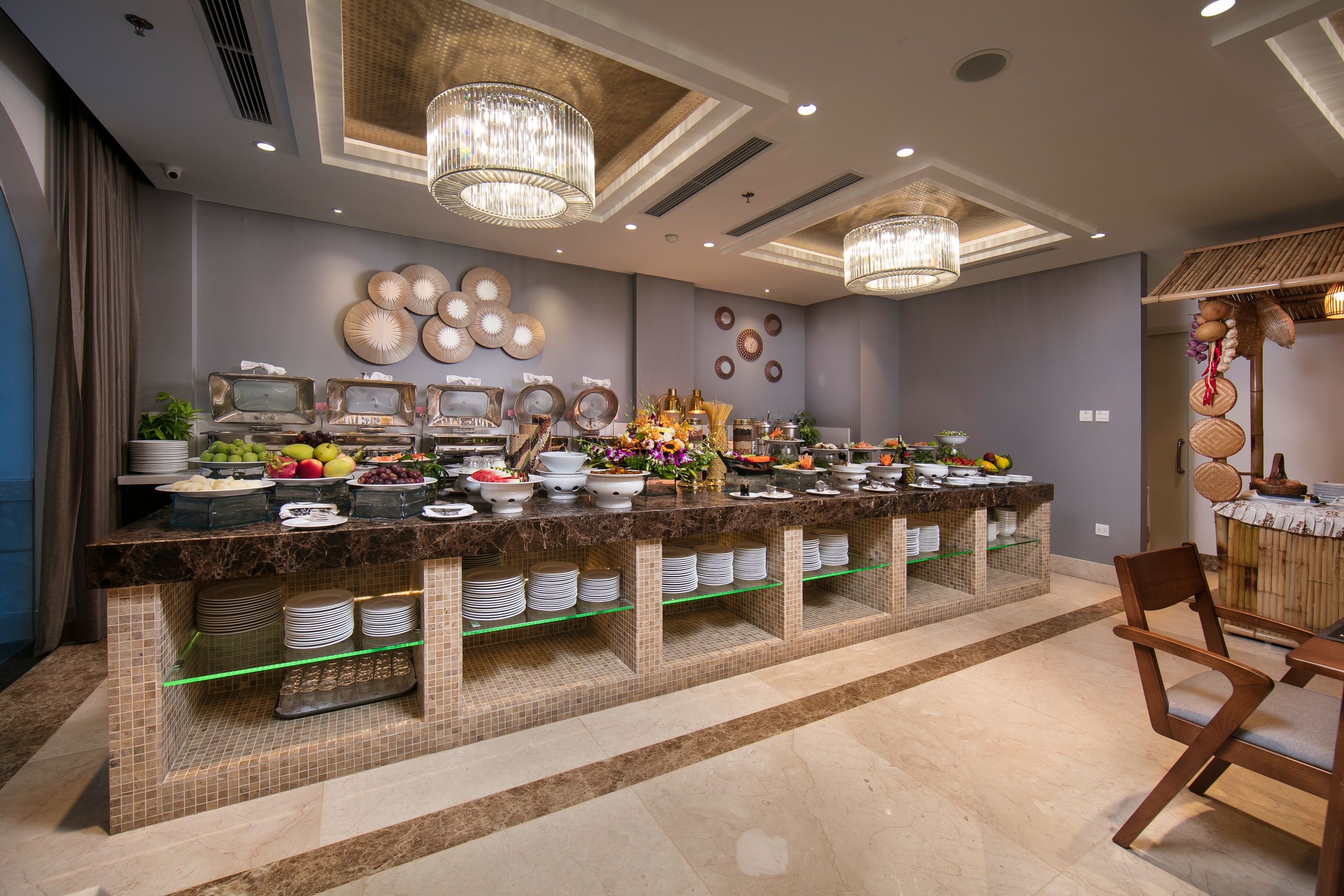A buffet setup with various food items and a seating area with chairs.