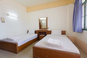 Habitación de hotel con dos camas individuales, un escritorio de madera, un espejo y una ventana con cortinas.