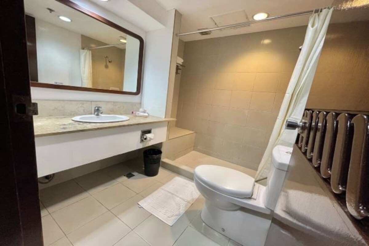 Un baño moderno con lavamanos, inodoro y zona de ducha.