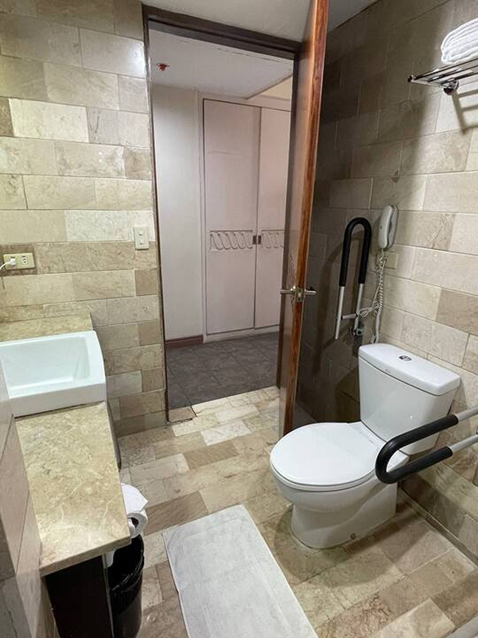 A bathroom with a toilet, a sink, and a shower area.