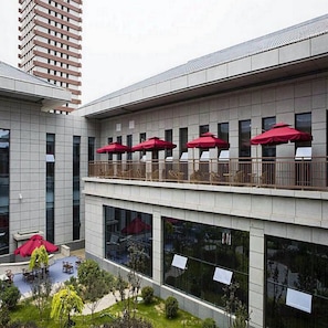 A modern building with a balcony and outdoor seating area. - Ningxia Xigang Airlines Hotel (Yinchuan)