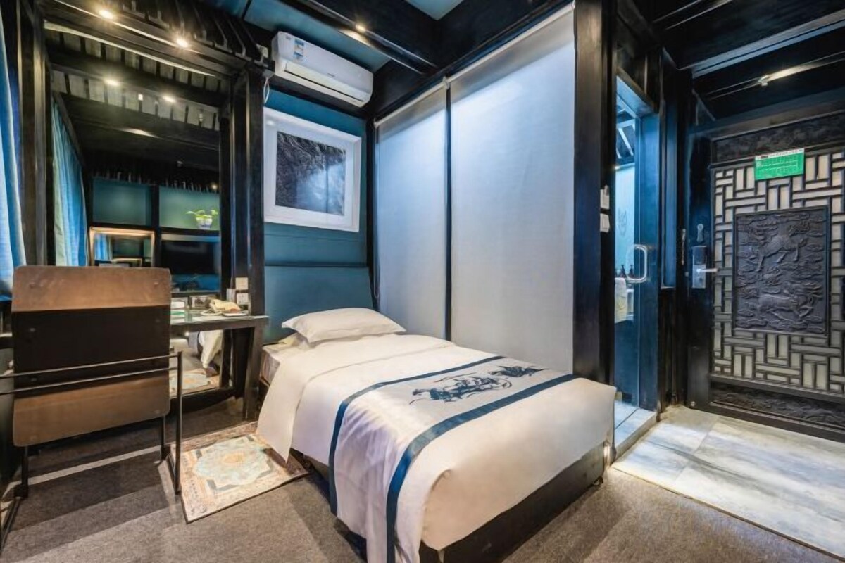 Habitación de hotel con cama, escritorio, silla y decoración en la pared.
