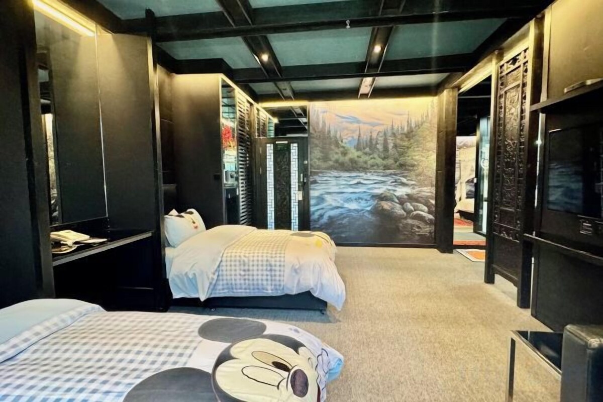 Un dormitorio con cama, escritorio y un ventanal con vistas a un río.
