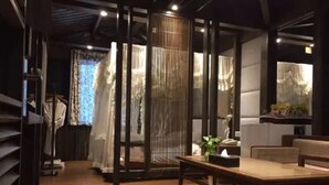 Un interior moderno con suelo de madera, una mesa central y una zona de estar.