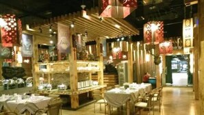 Un restaurante con decoración de madera y mesas preparadas para comer.