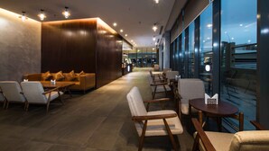 A modern interior with a seating area, wooden paneling, and large windows offering a view.